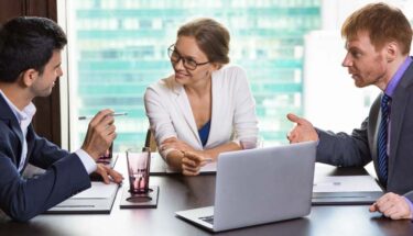 Three Australian corporate managers dicussing work related car expenses.