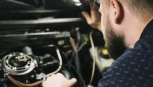 man checking vehicle engine