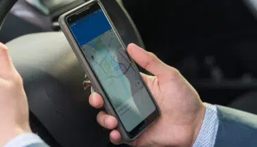 male driving while using smart phone