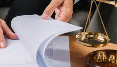 Male lawyer turning the document pages on the desk
