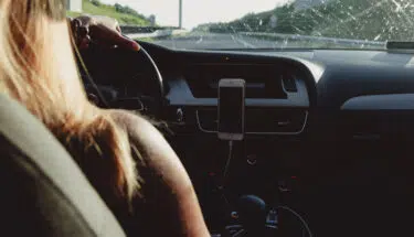 a woman driving her car while using a mobile phone